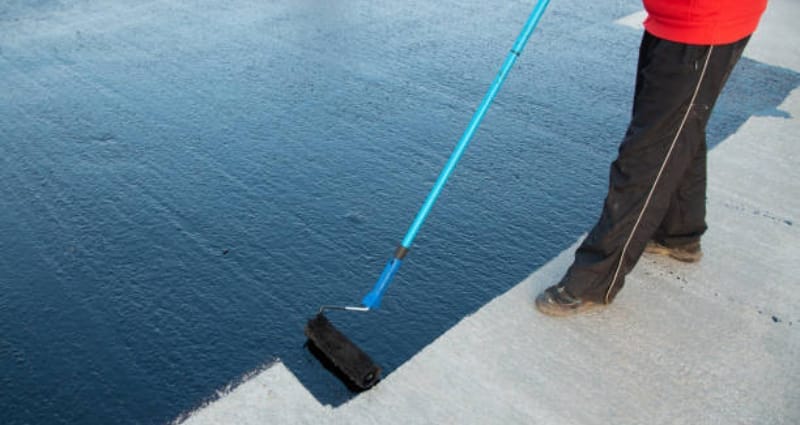 Waterproofing expert applying liquid PU coating with roller
